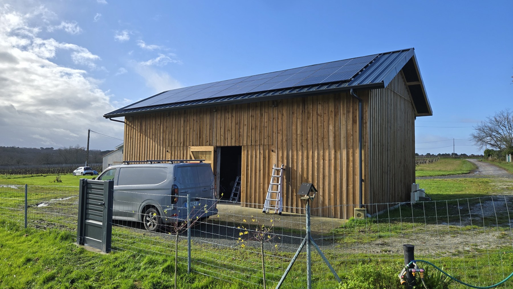 Bâtiment à bardage bois équipé de panneaux photovoltaïques en toiture